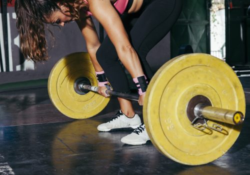 woman-with-yellow-barbell-gym